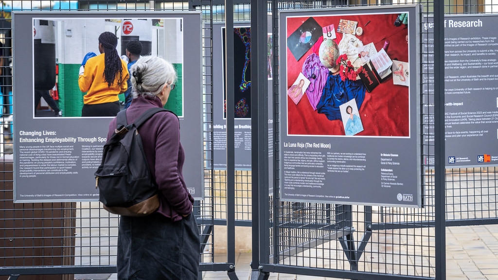 A community member stopping to look at an images of research poster