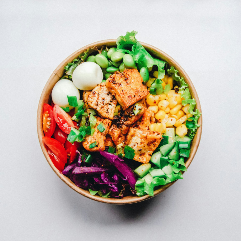 Bowl of healthy food - eggs, protein, tomatoes, greens. Photo by Anh Nguyen on Unsplash.