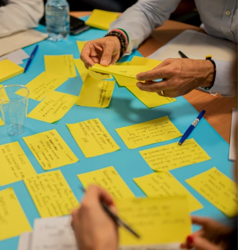 A close up shot of people working together with sticky notes.