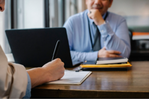 Two people sitting at a desk in a business meeting