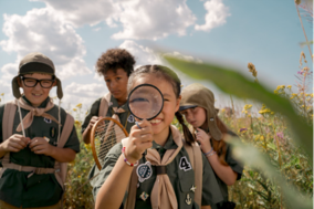 A group of children outside with magnifying glasses