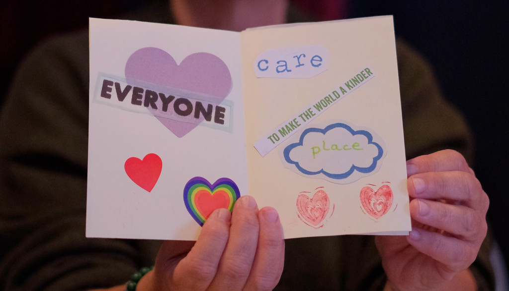 Example of a zine being held open by two hands. On one page are different coloured hearts with the word
