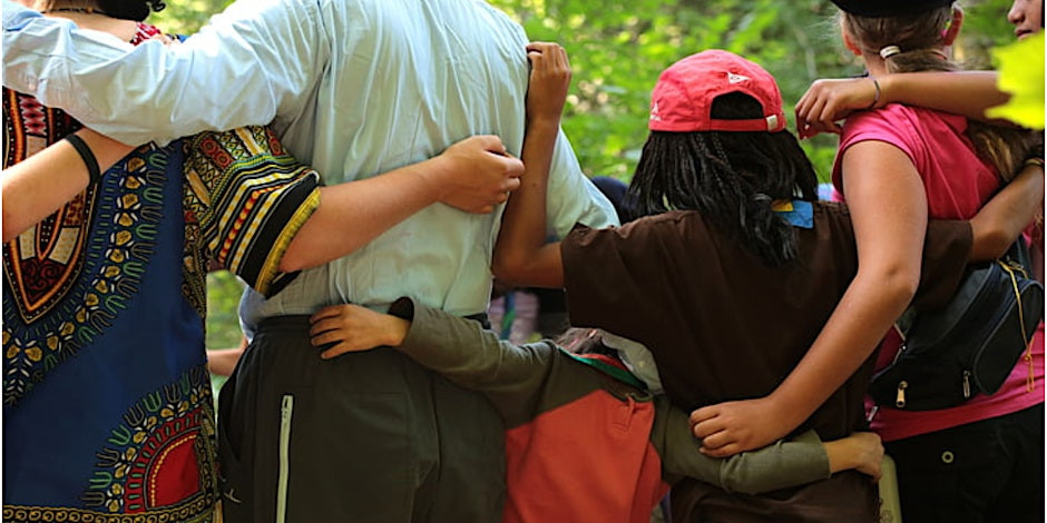 A picture of a handful of people embracing one another.