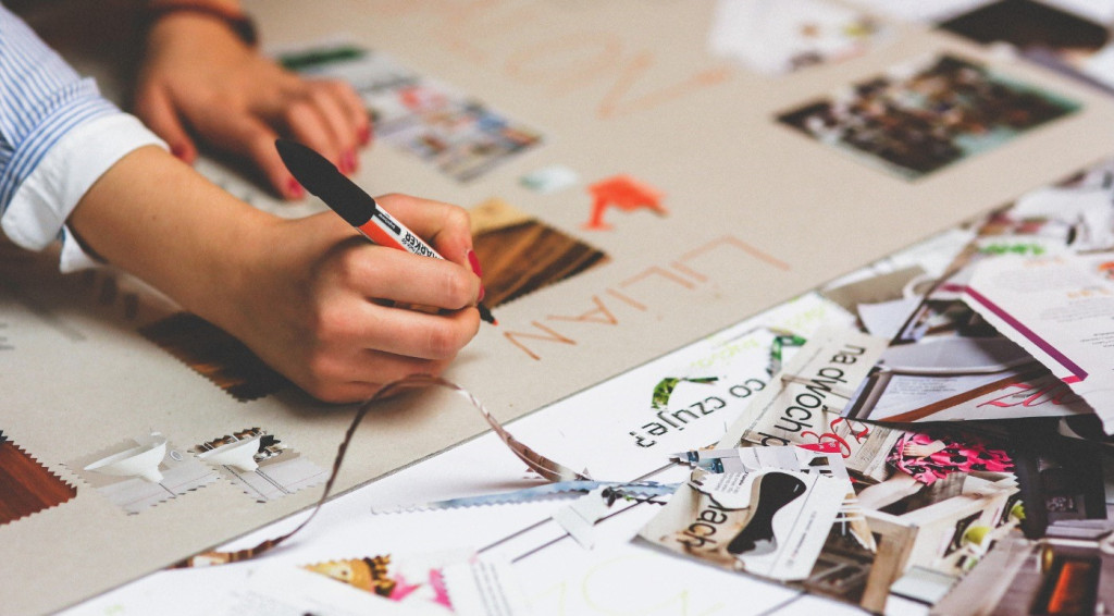 Someone making a collage and writing on it