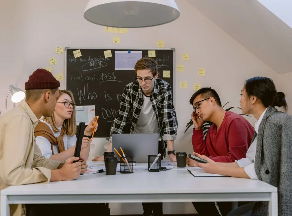Young people sit round a table having a discussion