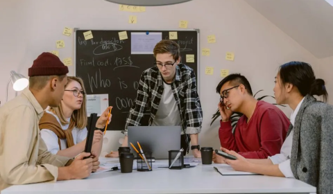 Young people sit round a table having a discussion