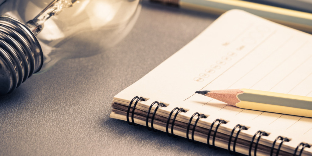 Photograph of a notebook and pencil on a desk