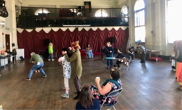 People engaging in different form of performance across an open stage.