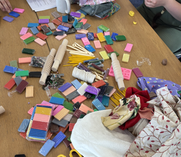 A scatter of craft materials, including colourful polymer clay on a table.
