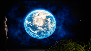 Chris Packham on the left looking at the earth in space.