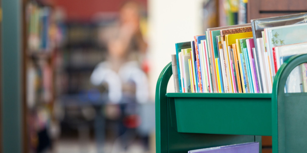 Photograph of books on a trolley in a library