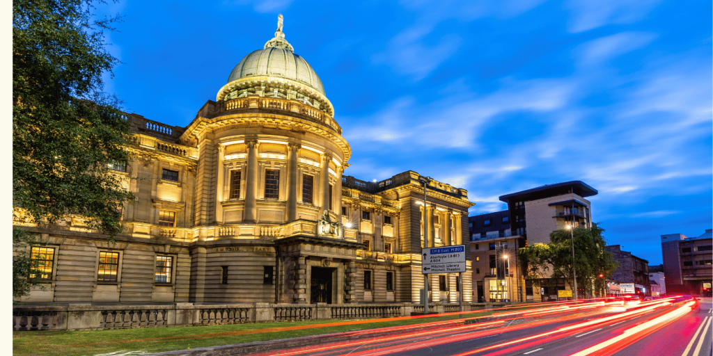 Mitchell Library in Glasgow Scotland with long beams of light in front from car backlights.