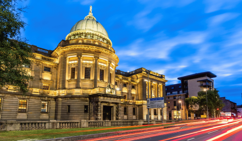 Mitchell Library in Glasgow Scotland with long beams of light in front from car backlights.