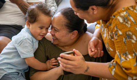Child and caregiver looking at a mobile telephone.