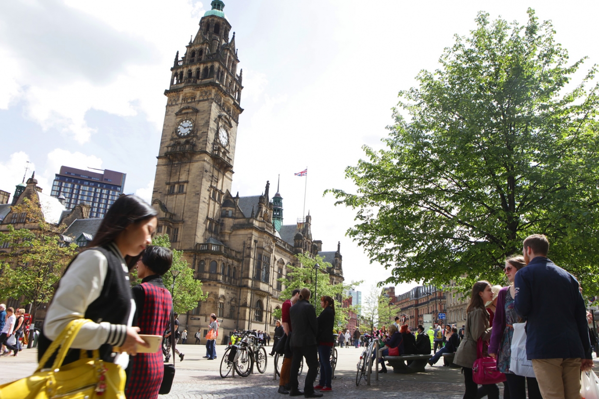 A photograph of Sheffield Town Hall with people in the foreground.