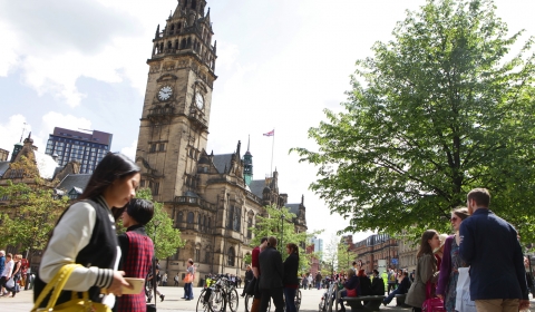 A photograph of Sheffield Town Hall with people in the foreground.