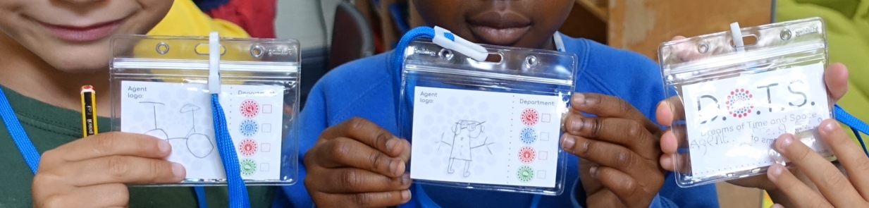 A child holds a special DOTS ID badge which they have designed