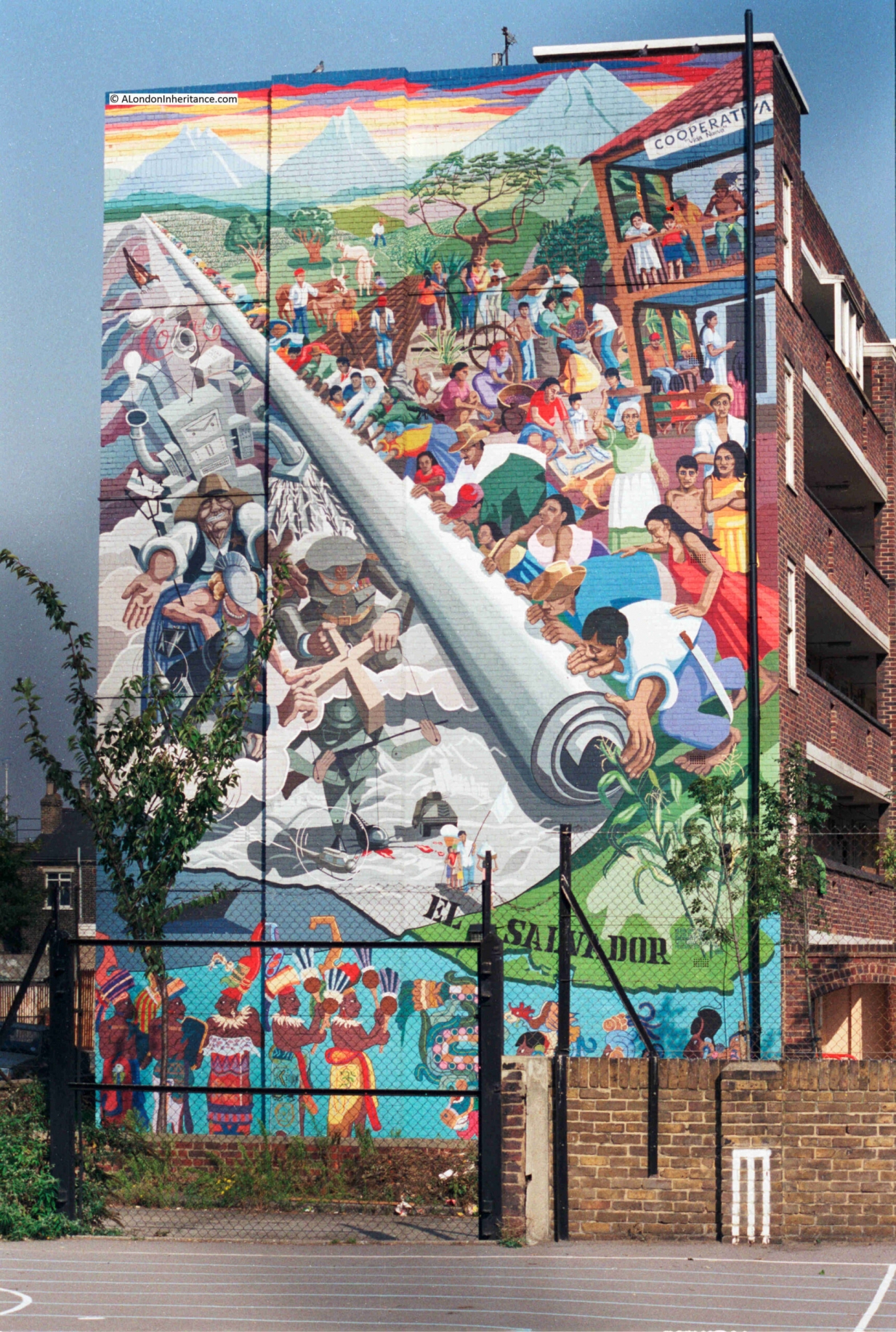 Mural, now faded, depicts a diverse community overcoming the forces of repression during the civil war in El Salvador