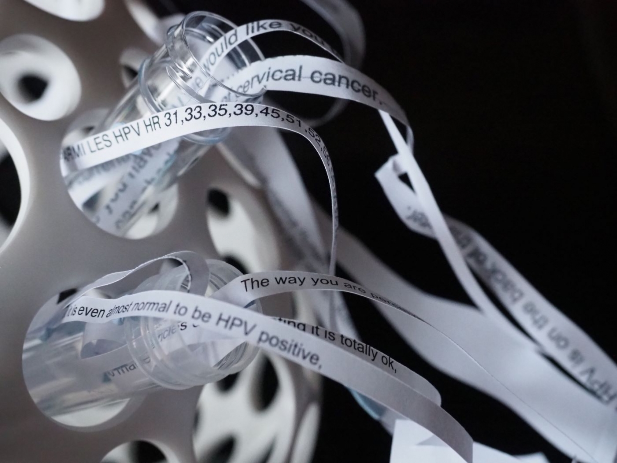 Paper sculpture of shredded patient leaflets flow from a testube holder