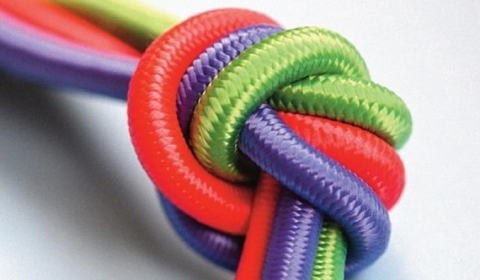 A stack of books with a colourful rope tied into a knot on the front