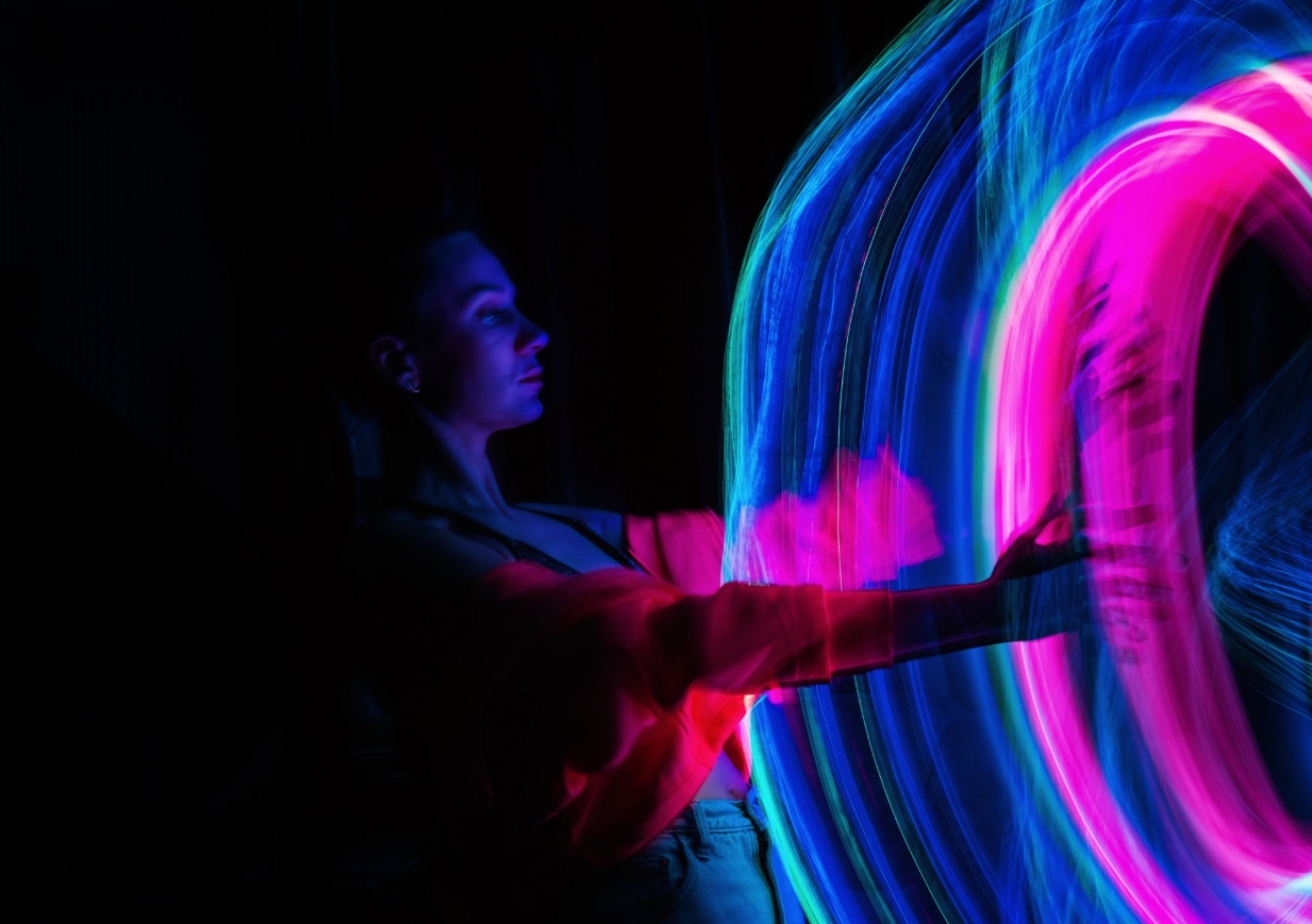 Person in front of a swirl of pink and blue light