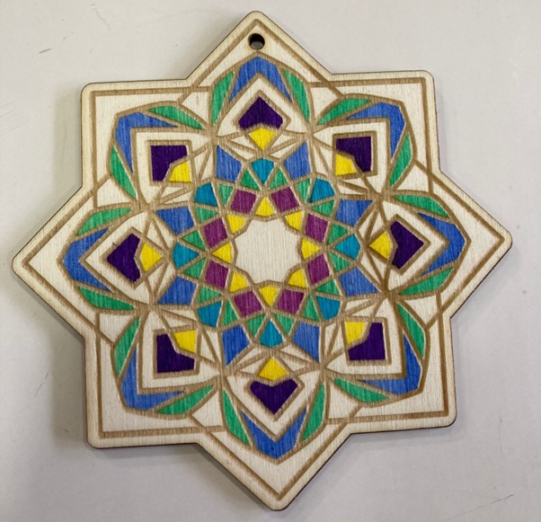 The picture shows a colourful wooden mandala on a white background.